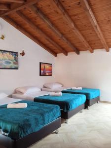 Zimmer mit 3 Betten und blauen Kissen in der Unterkunft Hospedaje Casa Versalles in Villa de Leyva