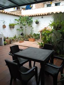 einen schwarzen Tisch und Stühle auf einer Terrasse in der Unterkunft Hospedaje Casa Versalles in Villa de Leyva