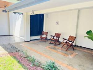 3 sedie a dondolo sedute su un patio di Alojamiento Tiquicia Valley a Alajuela