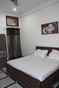 una camera da letto con un grande letto con lenzuola bianche di AK Corbett Family Homestay a Ramnagar