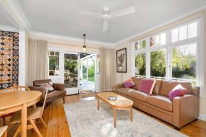 ein Wohnzimmer mit Sofa und Tisch in der Unterkunft Willow Tree Cottage in Bustling Creative Bundanoon in Bundanoon