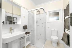 ein weißes Badezimmer mit Waschbecken und Toilette in der Unterkunft Willow Tree Cottage in Bustling Creative Bundanoon in Bundanoon + 38 Fotos