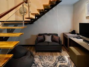 a living room with a couch and a staircase at The Litton Hotel by Carterson in Naga