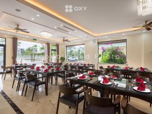 un restaurante con mesas negras, sillas y ventanas en Ha Long Essence Classic Hotel en Ha Long
