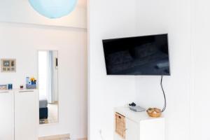 sala de estar con TV en una pared blanca en Sunrise en Kardámaina