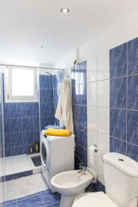 y baño de azulejos azules con aseo y ducha. en Sunrise en Kardámaina