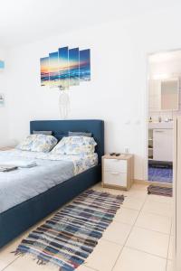 um quarto com uma cama azul e um tapete em Sunrise em Kardamaina