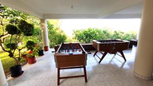 2 mesas de ping pong en un patio con plantas en Fun Guest House with Pool near Troodos en Perapedhi
