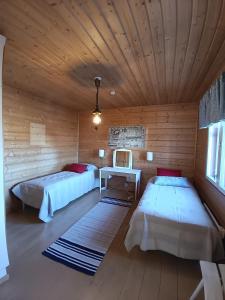 Habitación con 2 camas en una cabaña de madera en Saaristotila Jackois, en Iniö