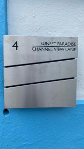 a metal sign that reads sunset paradise channelivist view lane at Sunset Paradise Oceanview 1-Bedroom Holiday Home Walking Distance to Beaches & Railway Trail in Hamilton