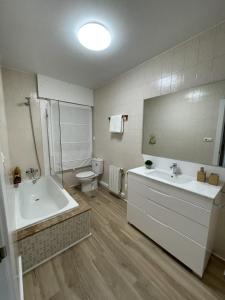 een badkamer met een bad, een wastafel en een toilet bij Mirador Puerto Náutico in Moaña