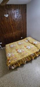 Una cama en un dormitorio con una manta amarilla. en Lo de nilda en Playa Unión
