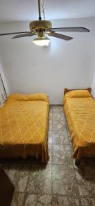 2 camas en una habitación con ventilador de techo en Lo de nilda en Playa Unión