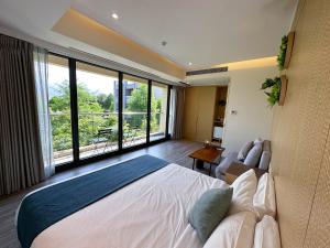 sypialnia z dużym łóżkiem i dużym oknem w obiekcie Villa LOHERB w mieście Dongshan