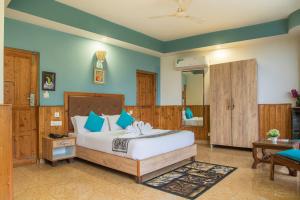 a bedroom with a bed with blue walls at Nandini villa in Dharmsāla