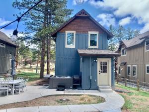 a blue house with a grill in a yard at Black Bear Cabin with Hot Tub in Woodland Park