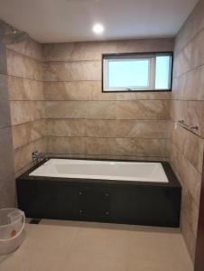 a bath tub in a bathroom with a window at Karapuram Village Resort & Spa in Mararikulam