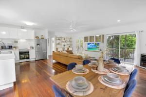 a kitchen and living room with a table and chairs at Tropical Refuge in Stratford