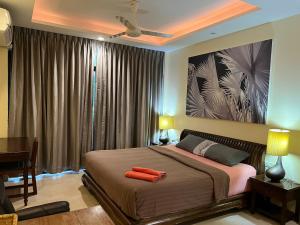 een slaapkamer met een groot bed, een bureau en een schilderij bij Blue Chang House in Bangkok