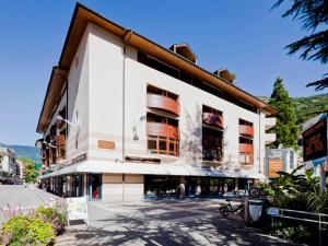 a large white building with balconies on a street at Studio avec balcon, parking et Wi-Fi au cœur de Brides-les-Bains - FR-1-512-266 in Brides-les-Bains