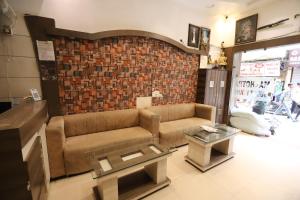 a living room with a couch and a brick wall at Malhotra Guest House 50 Meter from Golden Temple in Amritsar