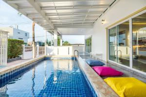 an indoor swimming pool with pillows in a house at Fira villa Huahin in Hua Hin