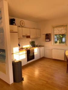 eine kleine Küche mit weißen Geräten und einem Fenster in der Unterkunft Freistehendes Einfamilienhaus mit Boddenblick Nähe Ostsee in Fuhlendorf