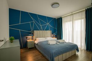 1 dormitorio con 1 cama grande y pared azul en Casa Lucan Brașov en Brasov