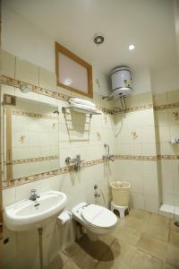 a bathroom with a sink and a toilet and a mirror at Malhotra Guest House 50 Meter from Golden Temple in Amritsar