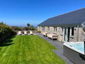 een tuin met een zwembad en een huis bij See Two Seas, Cape Cornwall in Penzance