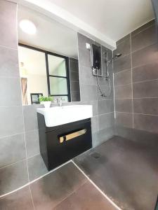 ein Bad mit einem Waschbecken und einem TV an der Wand in der Unterkunft FREE Parking, 1-5 Pax Soho LOFT Empire Damansara in Petaling Jaya