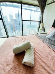 ein Handtuch auf einem Bett in einem Zimmer mit Fenster in der Unterkunft FREE Parking, 1-5 Pax Soho LOFT Empire Damansara in Petaling Jaya