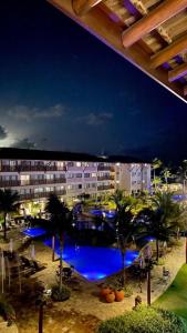 vistas a una piscina con palmeras y edificios en La Fleur Polinesia Residence & Resort, en Porto de Galinhas