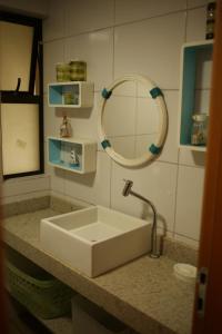uma casa de banho com um lavatório branco e um espelho. em La Fleur Polinesia Residence & Resort em Porto de Galinhas