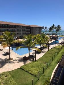 uma vista para um resort com uma piscina e palmeiras em La Fleur Polinesia Residence & Resort em Porto de Galinhas