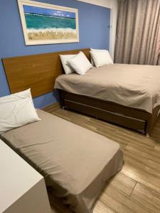 2 camas en una habitación con el océano en la pared en La Fleur Polinesia Residence & Resort, en Porto de Galinhas