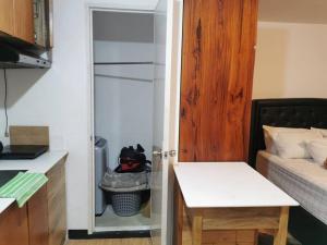 ein kleines Zimmer mit einem Bett und einer Tür zu einem Schrank in der Unterkunft Kate's Studio Unit in Davao City