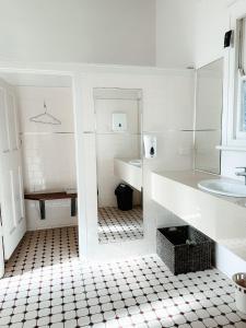 a white bathroom with a black and white tiled floor at Central Hotel Stroud in Stroud