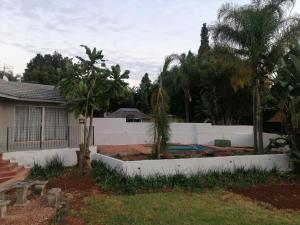 a backyard with a white fence and a pool at Villa Pretoria in Pretoria