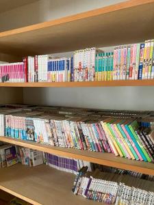 a book shelf filled with lots of books at 一棟貸し別荘つる in Matsue