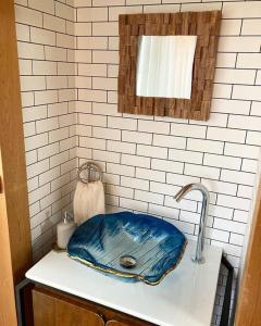 ein Waschbecken in einem Badezimmer mit einer blauen Schüssel in der Unterkunft 一棟貸し別荘つる in Matsue + 37 Fotos