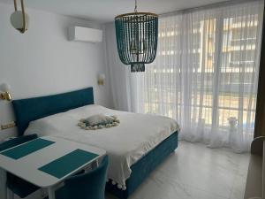 a bedroom with a bed and a table and a chandelier at Pearl in Ravda