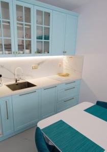 a kitchen with blue cabinets and a sink and a table at Pearl in Ravda