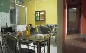 a dining room with a glass table and chairs at Drishtee Homestay in Rongli