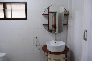 a bathroom with a sink and a mirror on the wall at บ้านใจกลางเมืองศรีสะเกษ 3นอน2น้ำ in Si Sa Ket