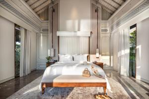 a bedroom with a large bed and a chandelier at Jumeirah Bali in Uluwatu