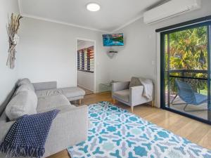 a living room with a couch and a chair at Beachside Palms Unit 2 in Nelly Bay