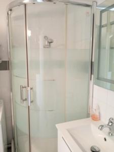 a shower with a glass door next to a sink at Les Boramars 4 23 climatisé wifi 300m plage in Argelès-sur-Mer
