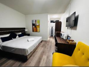 a bedroom with a bed and a desk and a yellow chair at OUYEN MOTEL in Ouyen