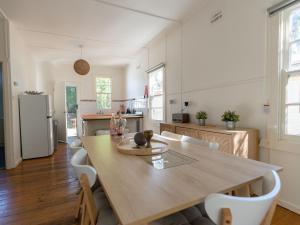 a kitchen and dining room with a wooden table and chairs at Charlie's Beach House in Byron Bay